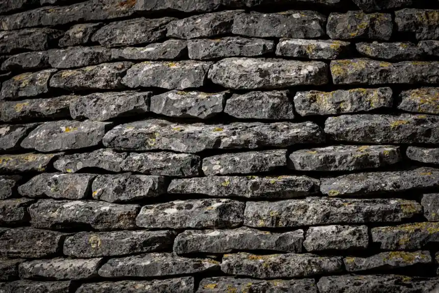 Close-up view of a textured stone wall with stacked rocks.